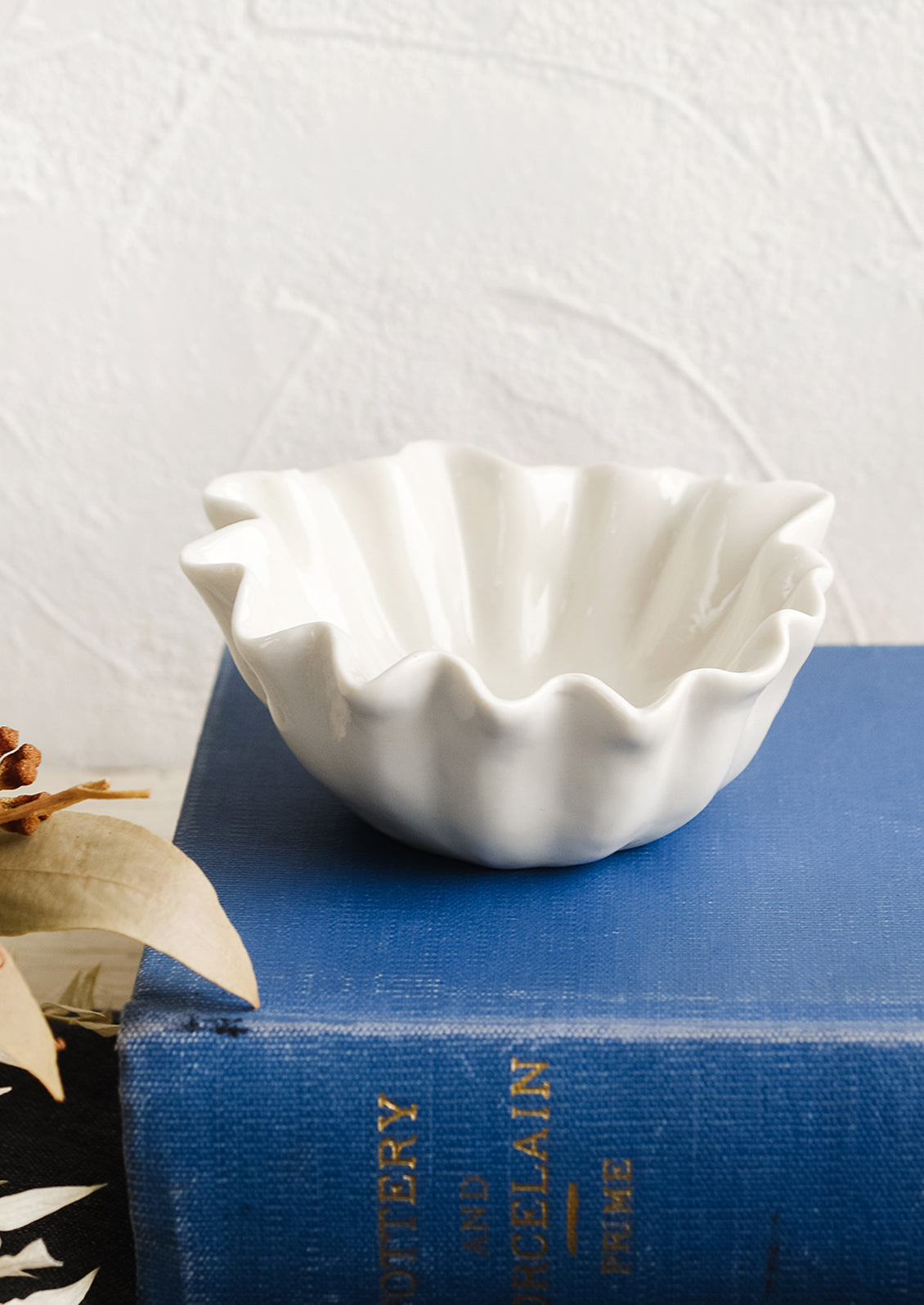A white bowl with wavy shell-like shape.