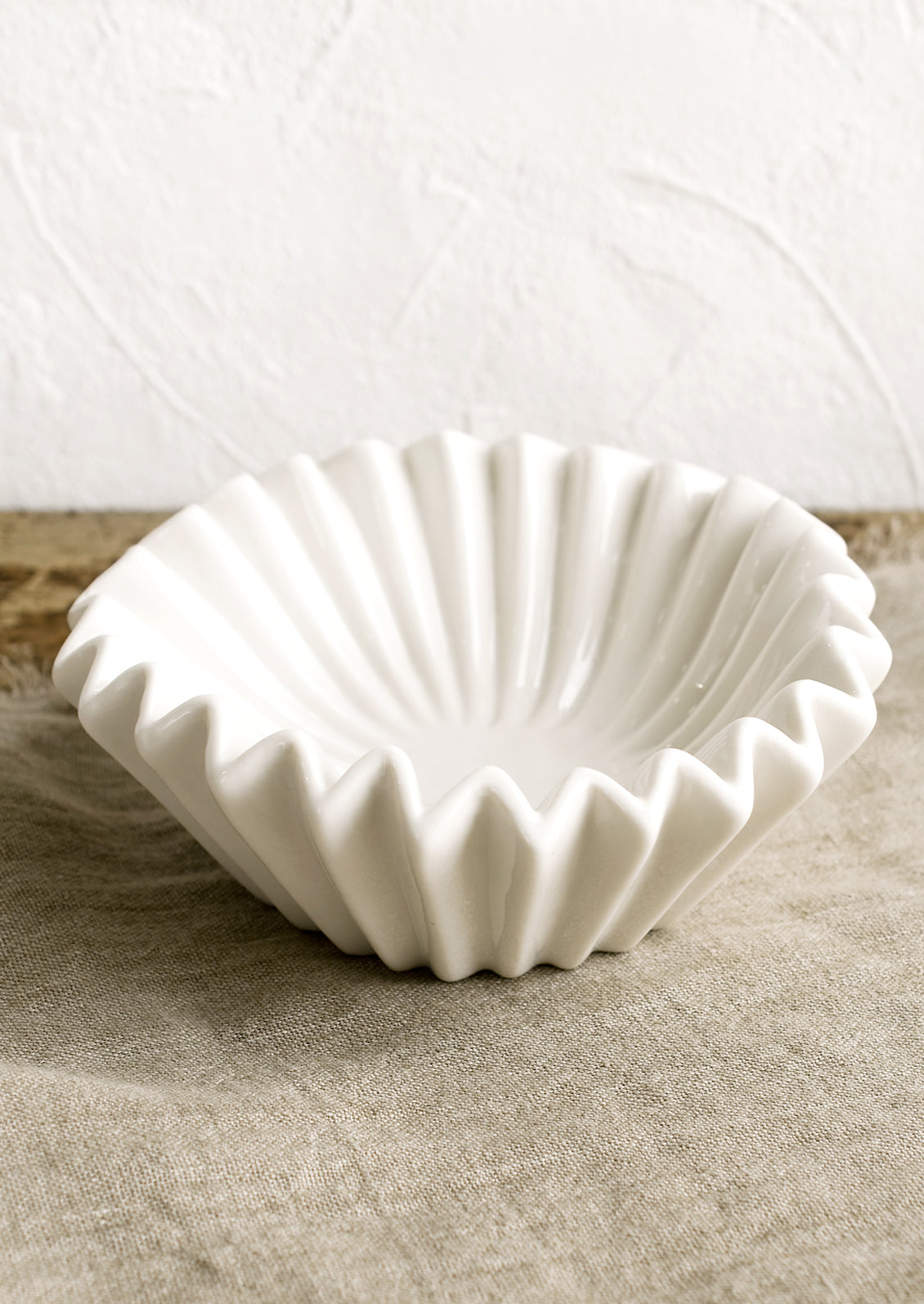 A white bowl with folded/pleated design.
