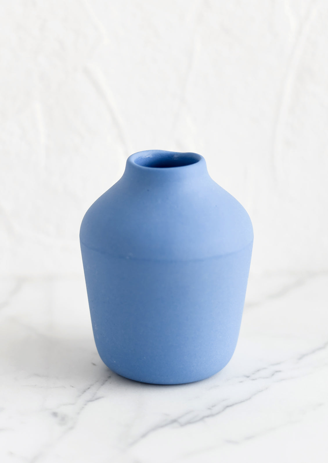 A cornflower colored porcelain bud vase.
