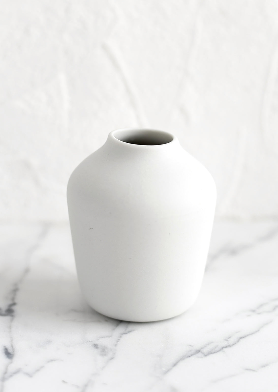 A white porcelain bud vase.