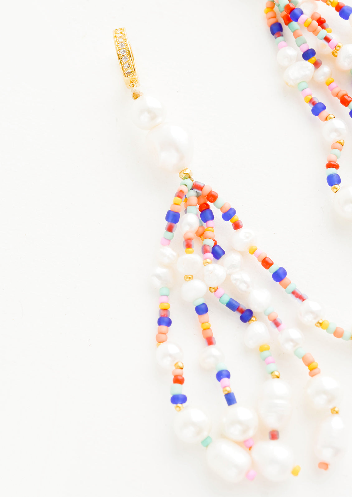 Earrings with multiple, heavily beaded dangling strands of large pearls mixed with small colorful beads