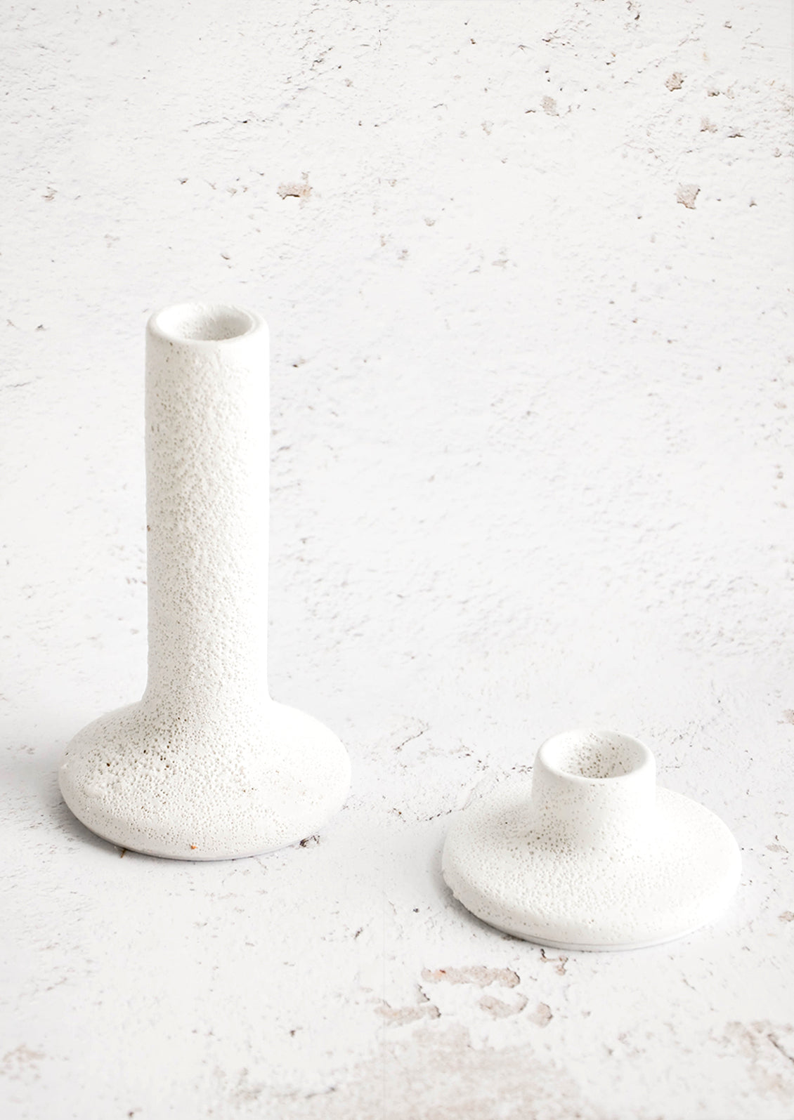 Taper candle holders in short and tall heights, made in rough textured white ceramic