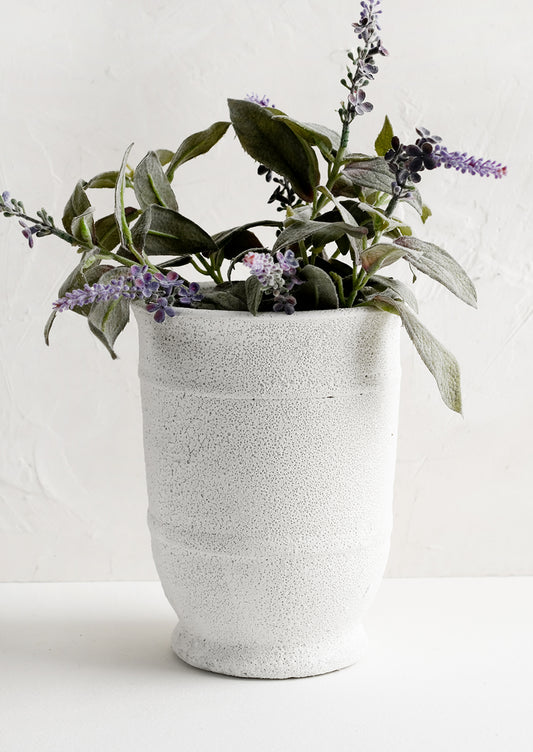 A tall planter in textured white glaze with lavender plant.