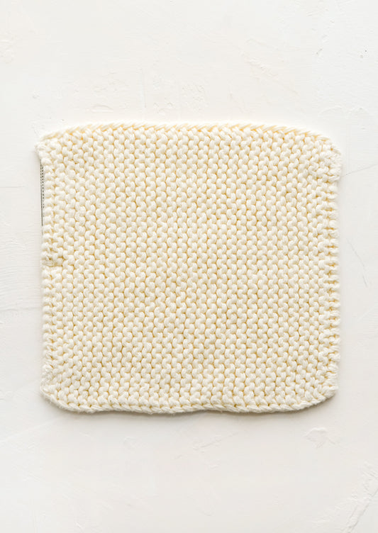 A square, chunky knit cotton potholder in off white.