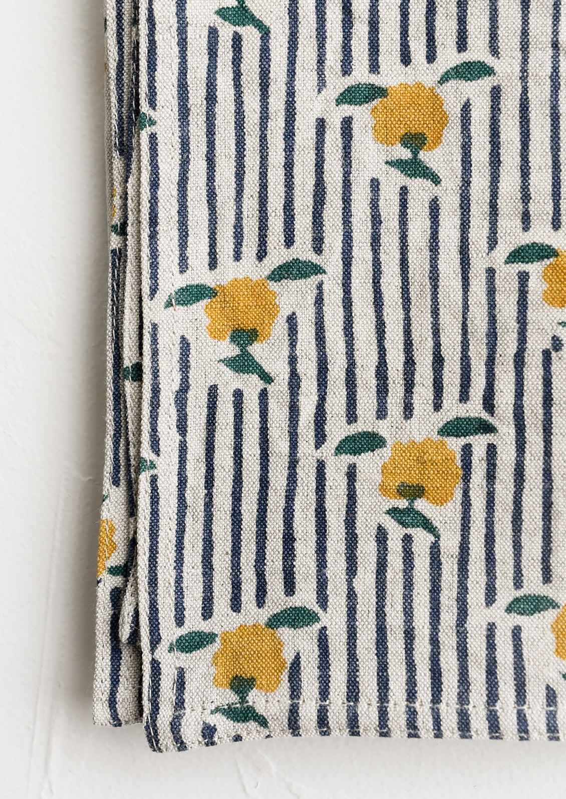 A block printed cotton napkin in stripe and floral pattern.