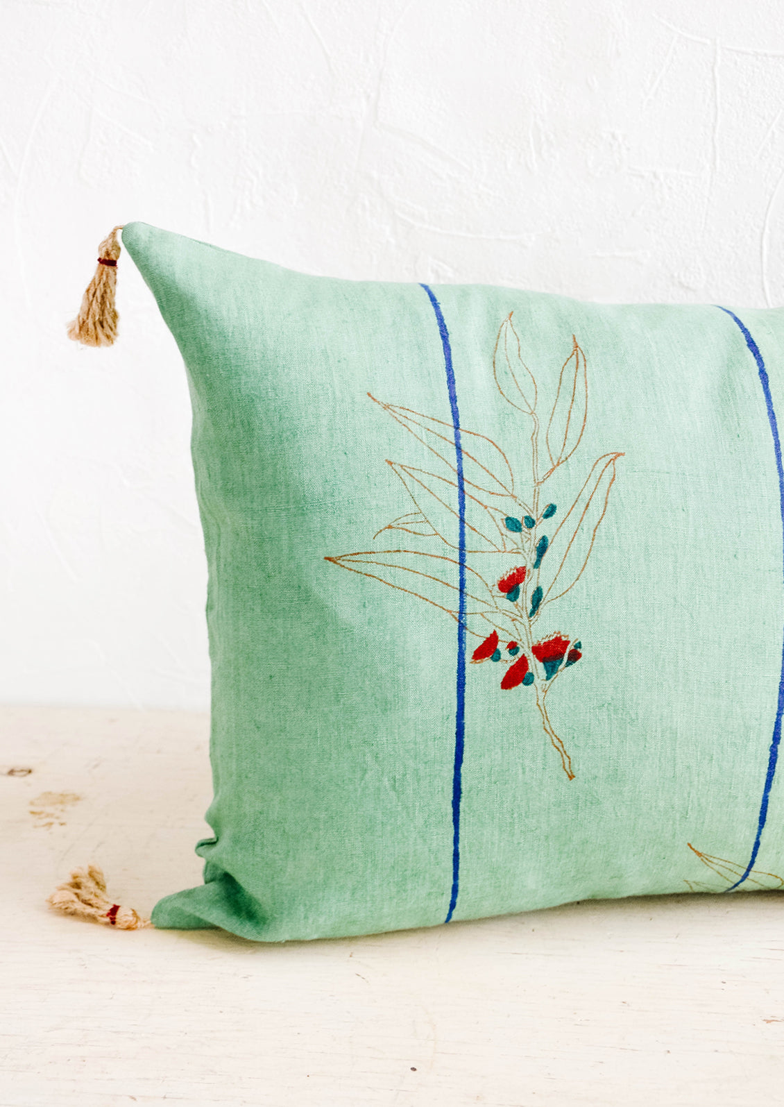 Decorative lumbar throw pillow with block printed floral and stripe print and jute tassels at corners