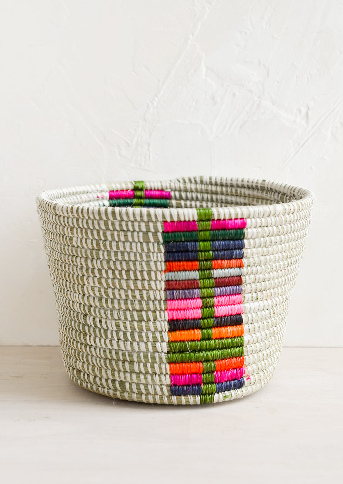 A round planter basket with colorful panel at front.
