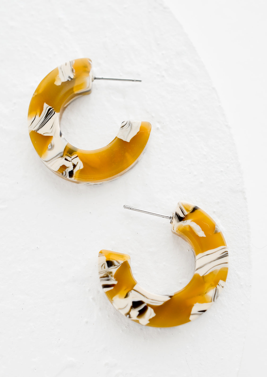 A pair of acetate hoop earrings in butterscotch.