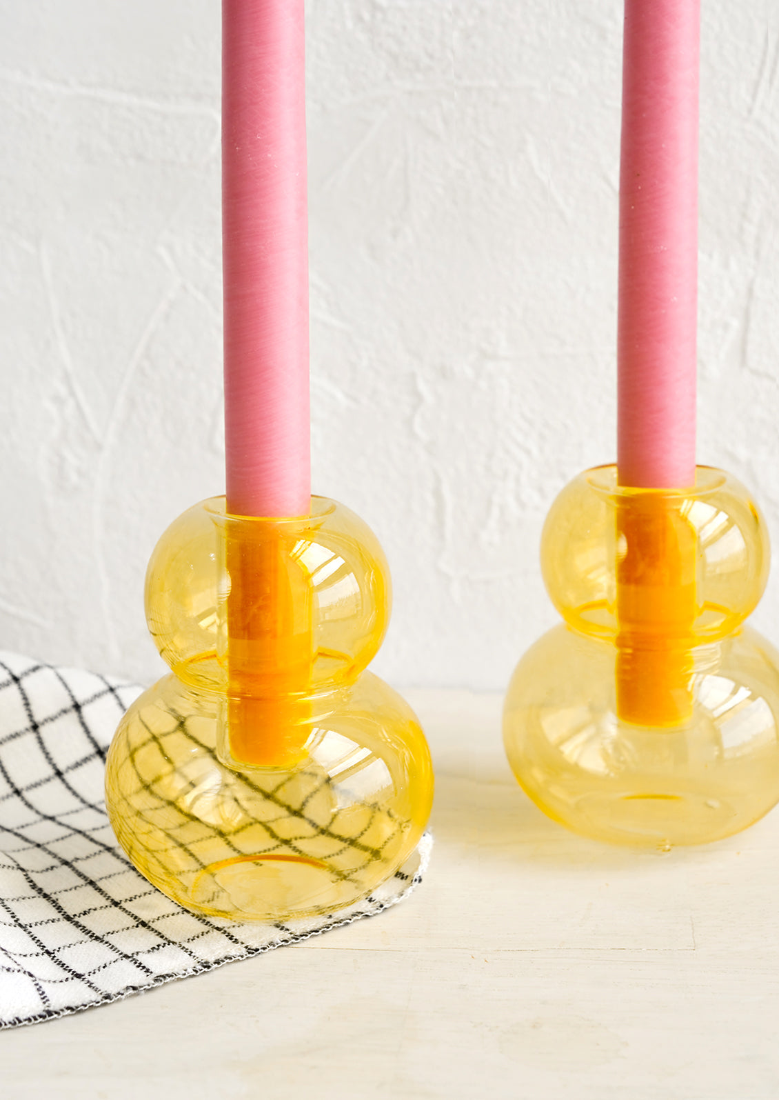 A bubble shaped glass taper candle holder in honeycomb yellow-orange.