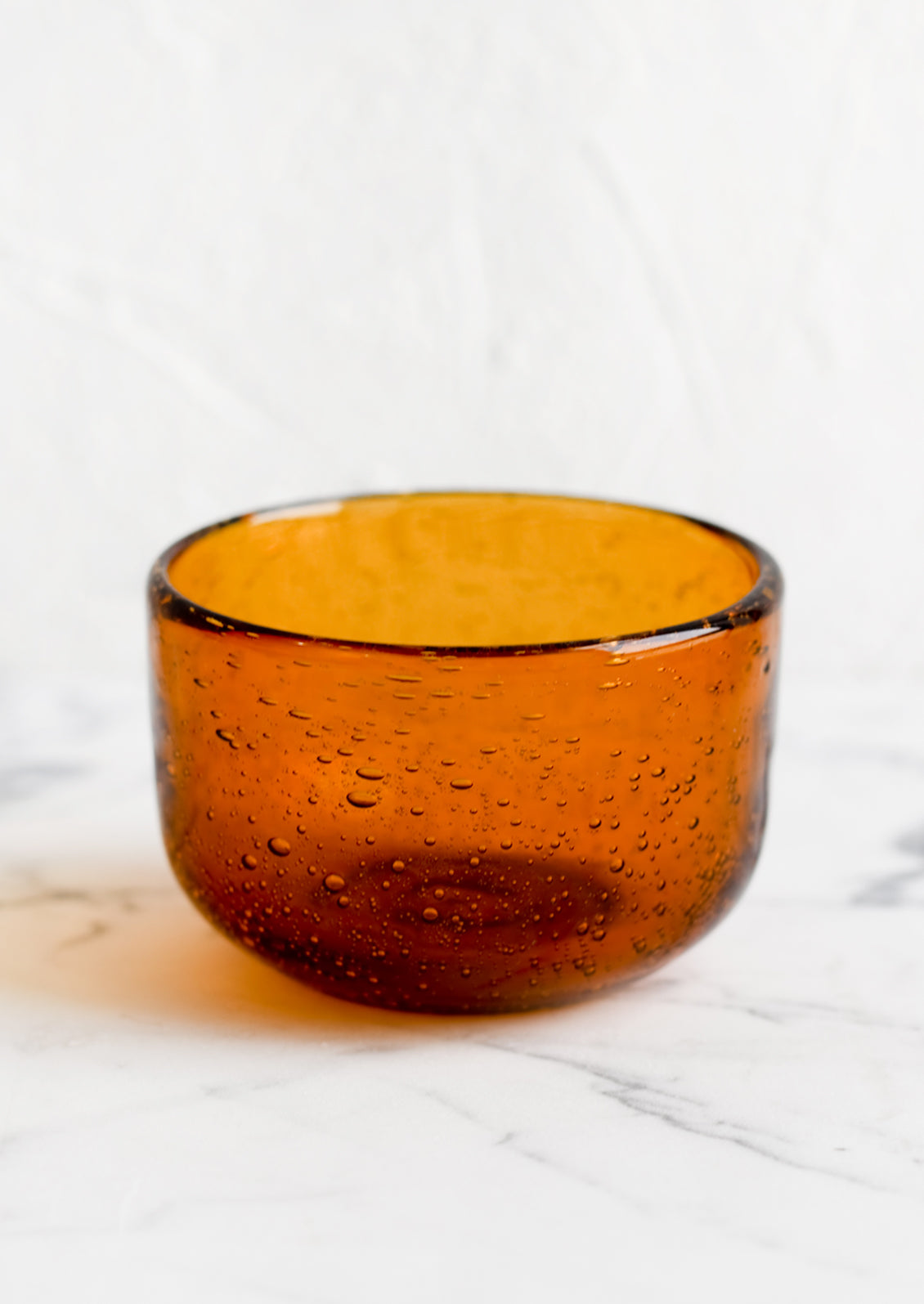 A small recycled glass bowl in clear amber color.