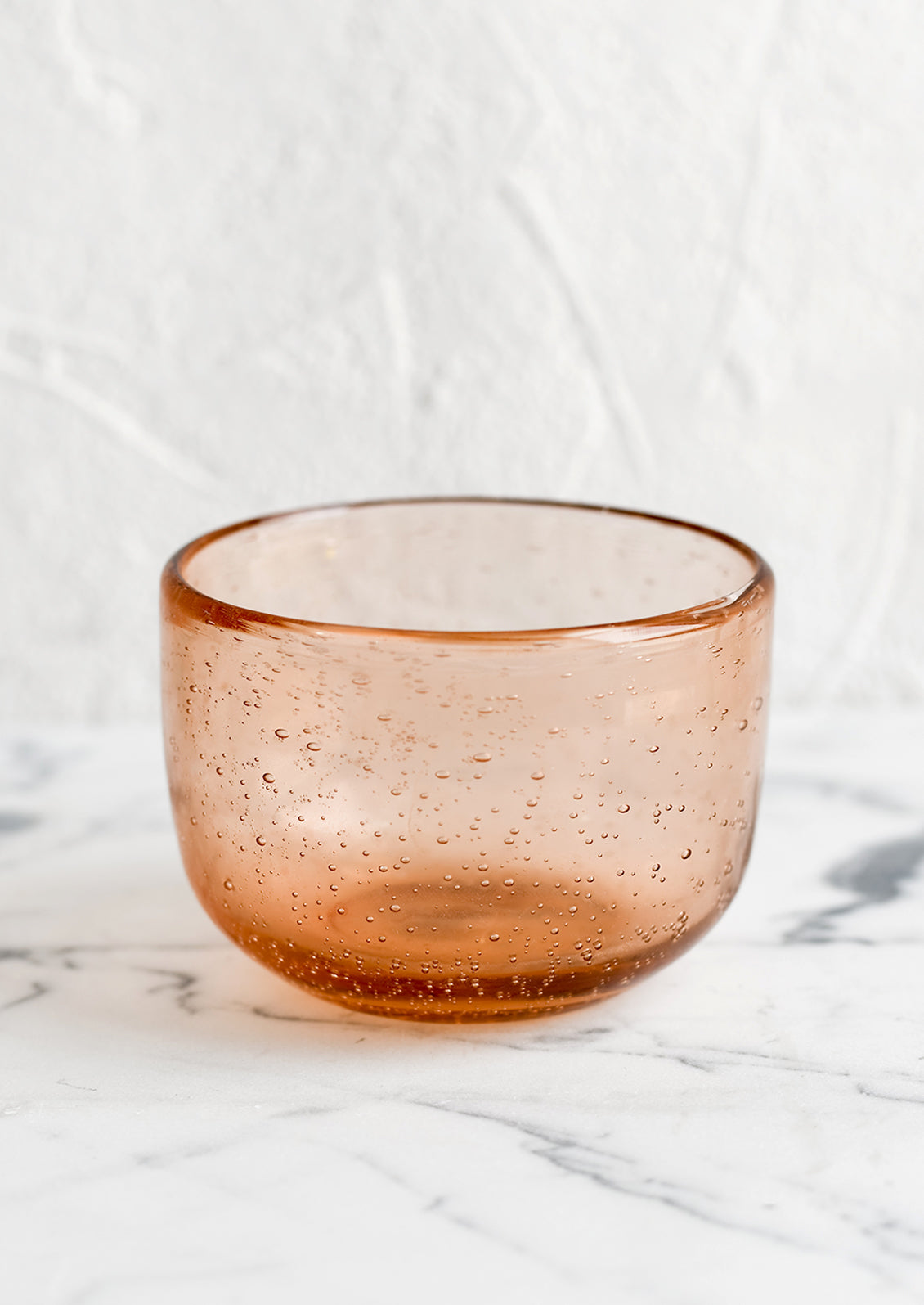 A small recycled glass bowl in clear melon color.