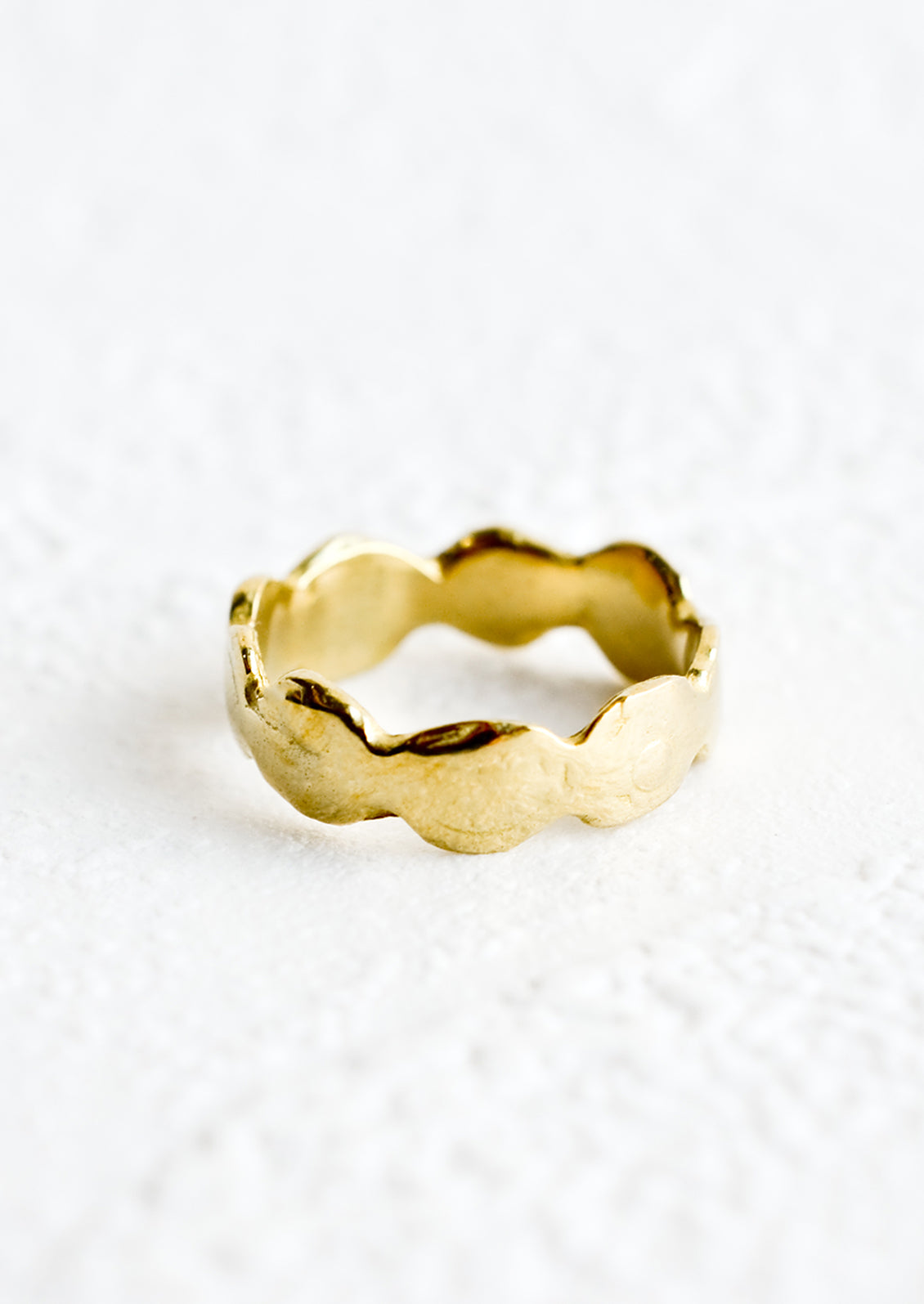 A brass ring in an organic, curvy shape.
