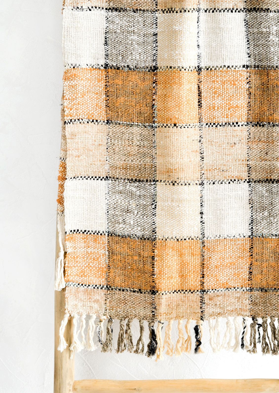 A table runner in shades of brown, black and white with checker pattern.