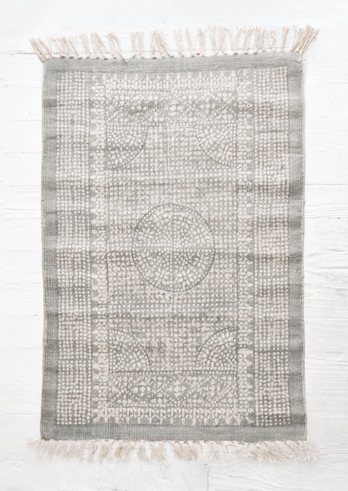 Flatweave rug with contrasting oriental pattern and fringe trimmed edges on two sides