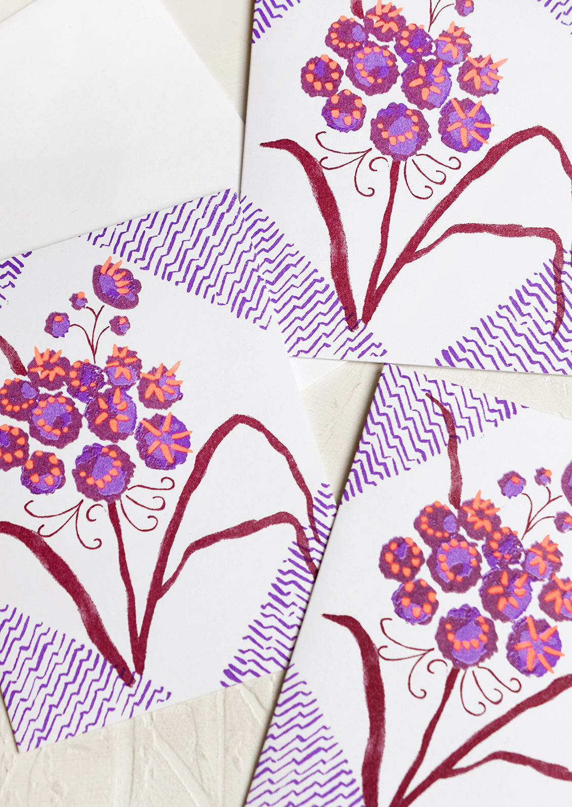 A floral print card set in purple, wine and neon orange.
