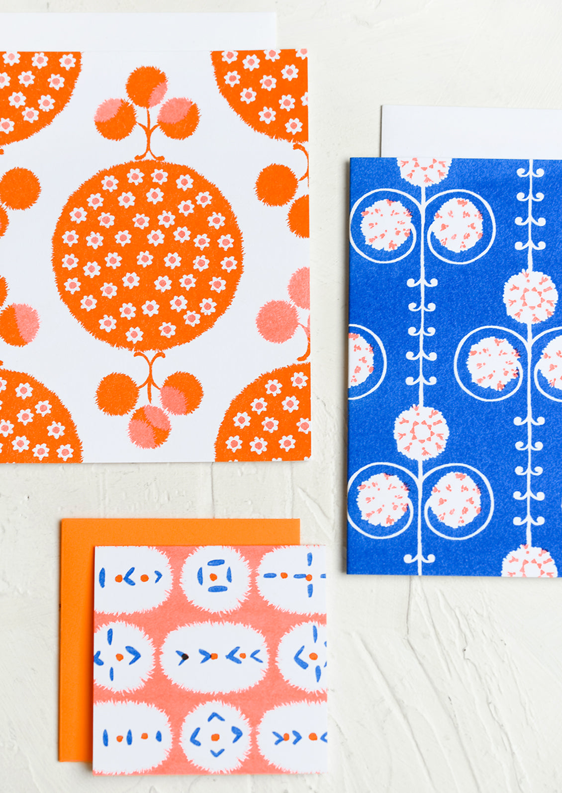 A patterned risograph printed card set in cobalt and orange.
