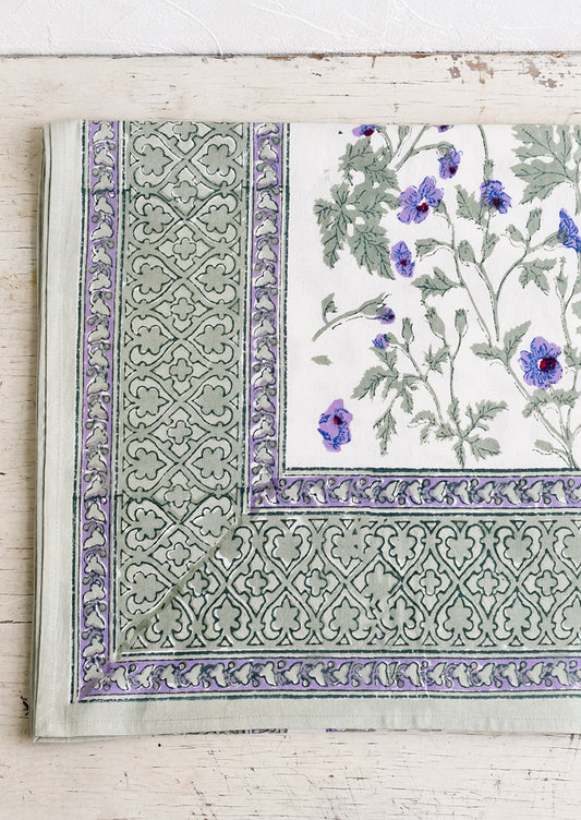 A block printed floral tablecloth in purple and green floral.