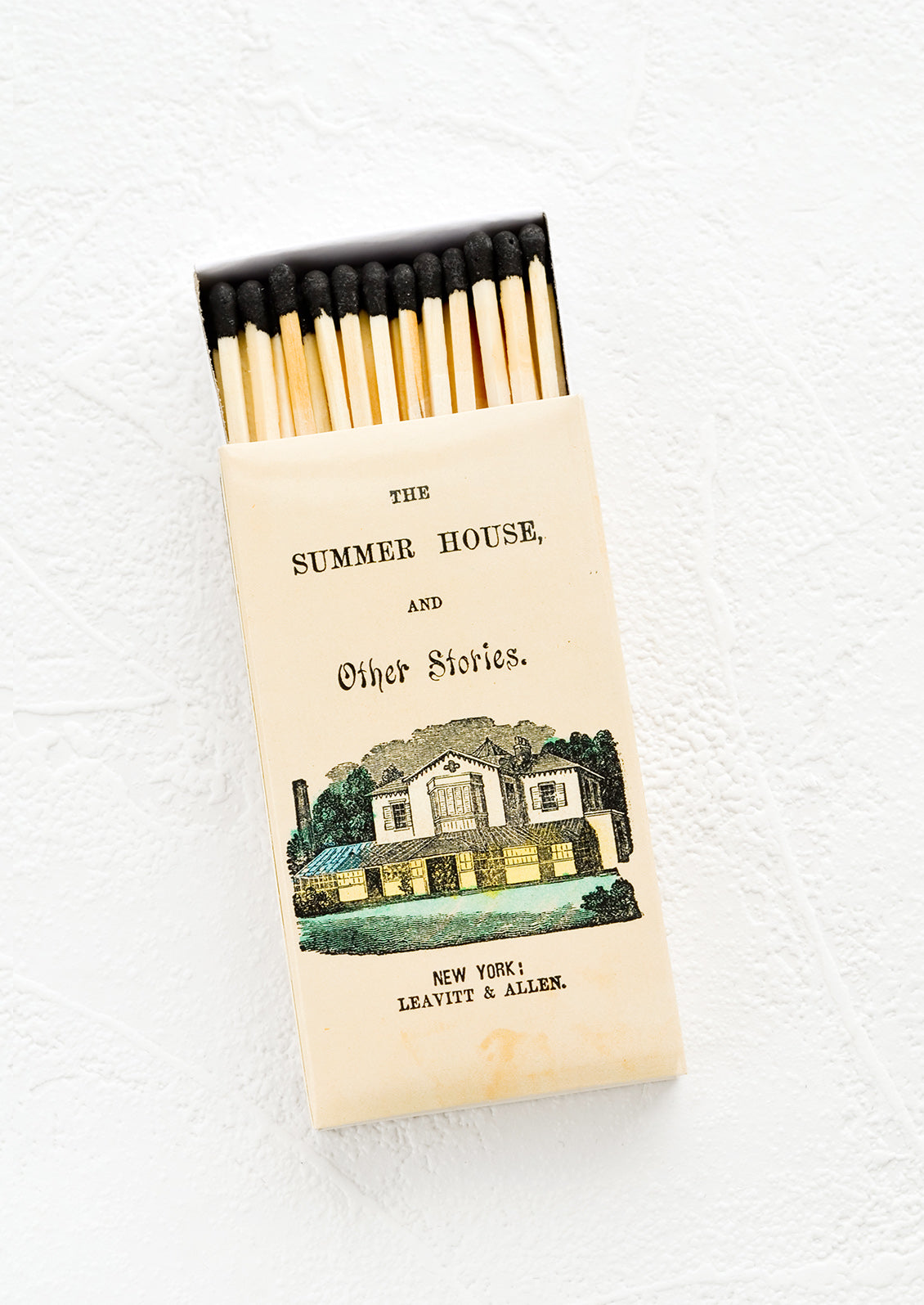 A printed matchbox with long, black-tipped matches.