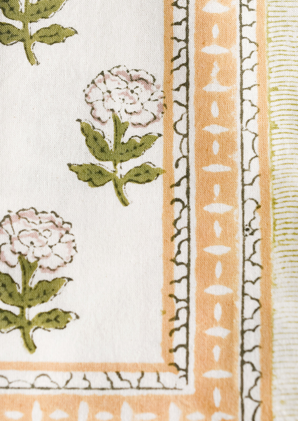 A pair of block printed floral napkins in green, mustard and lavender palette.