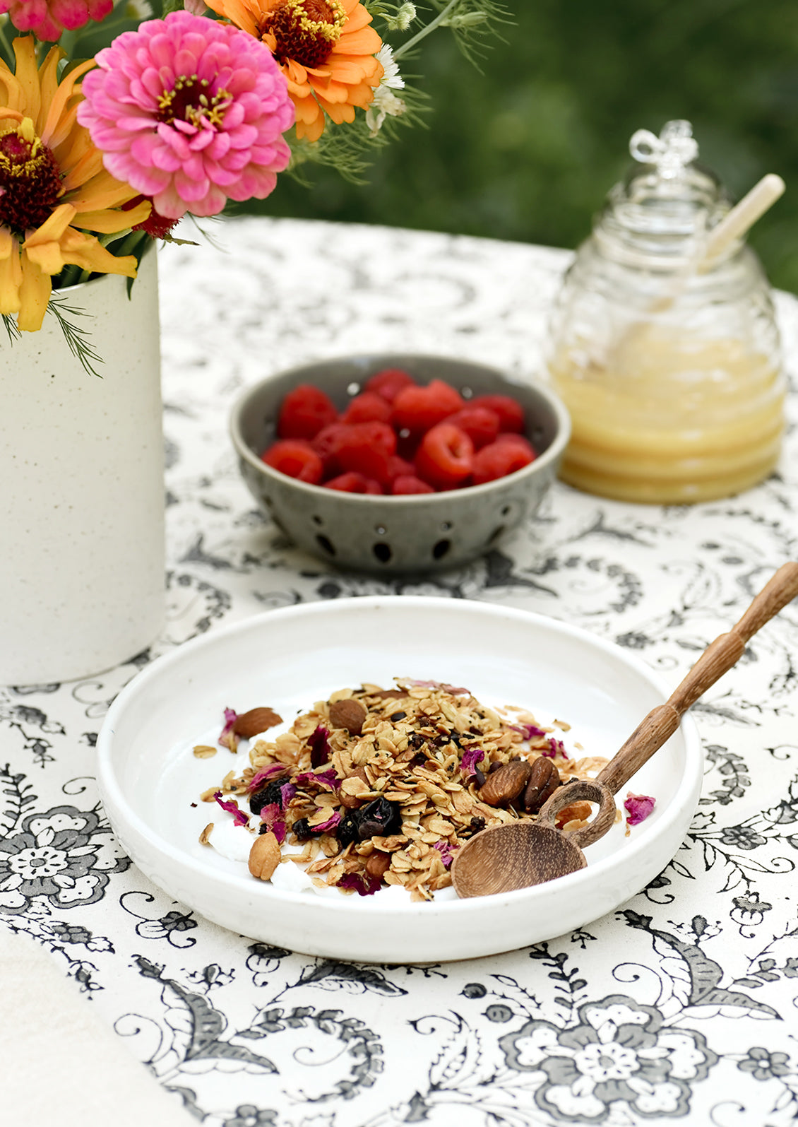A white ceramic bowl with granola and yogurt.