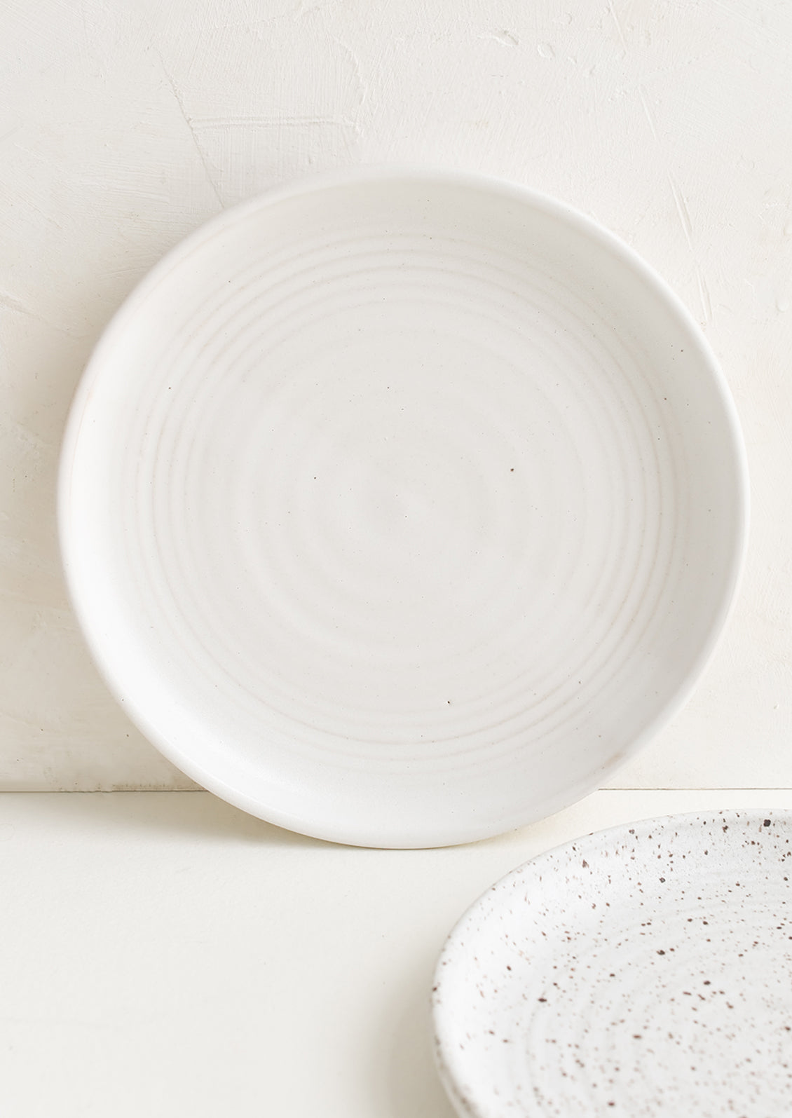A ceramic side plate in a matte white glaze.