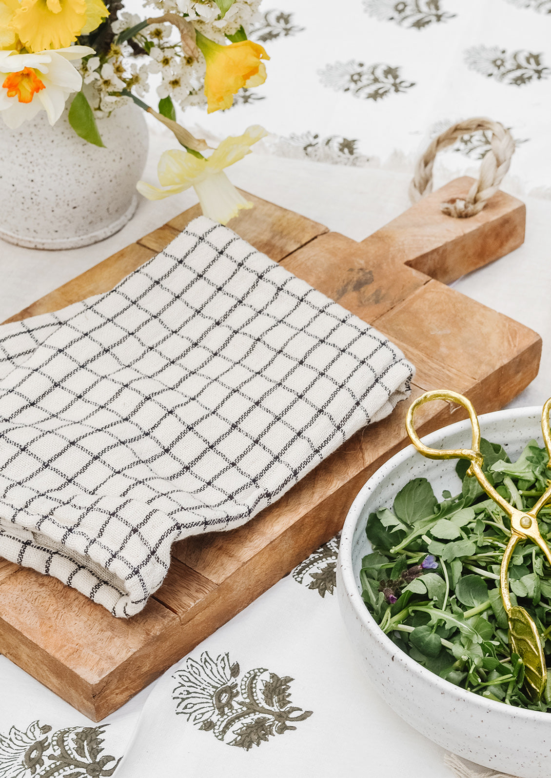 A tea towel and wooden serving board.