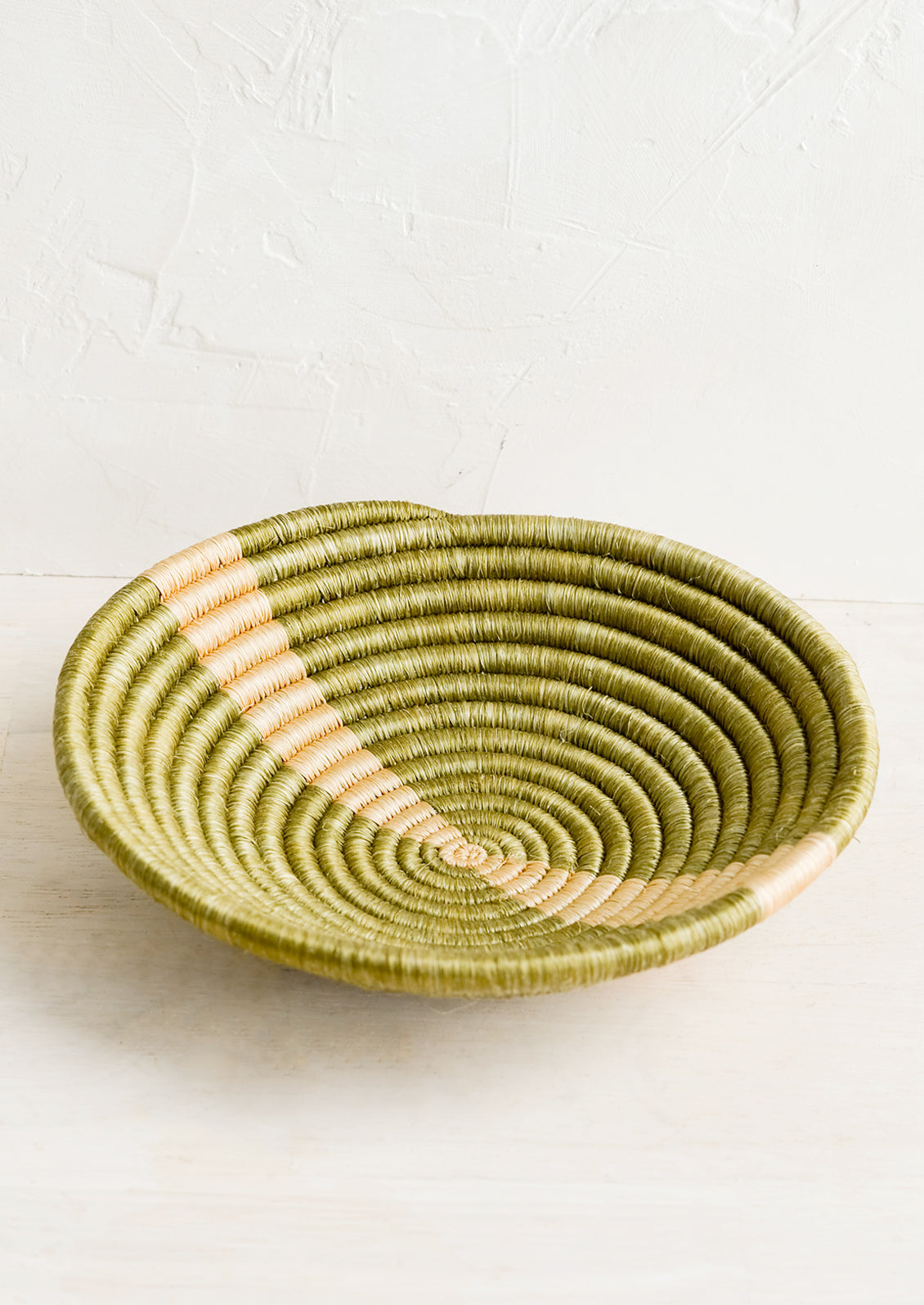 A small sweetgrass catchall bowl in khaki with tan stripe.