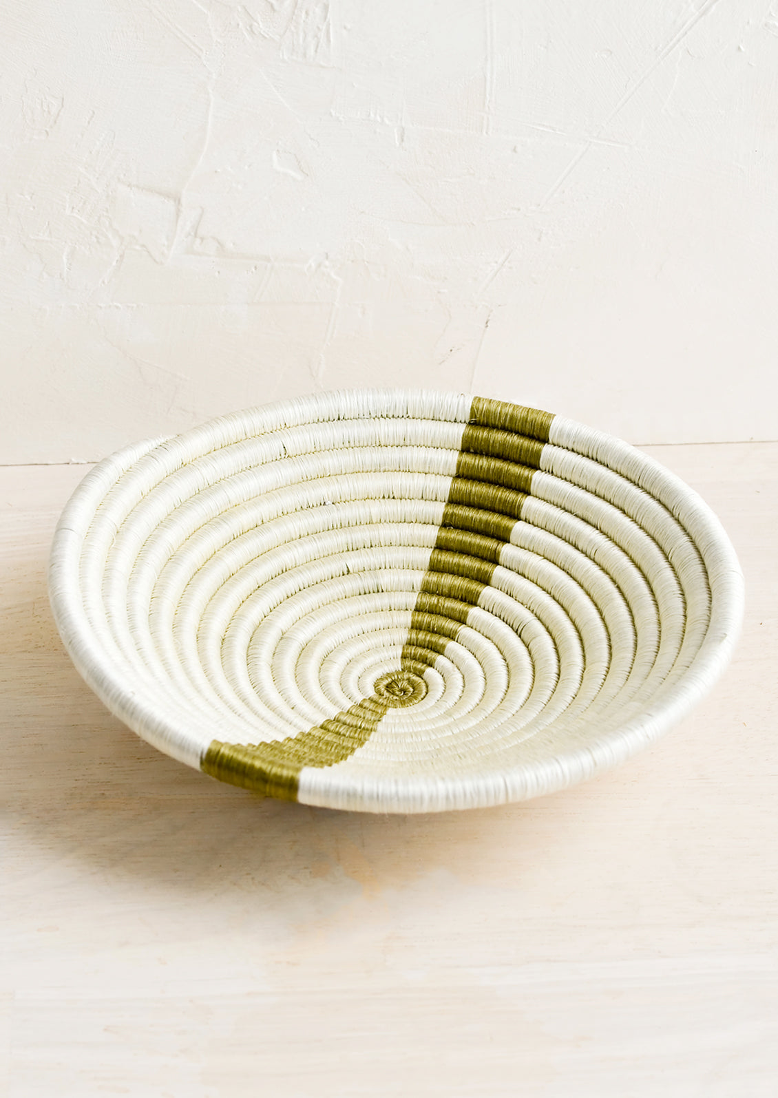 A small sweetgrass catchall bowl in white with khaki stripe.