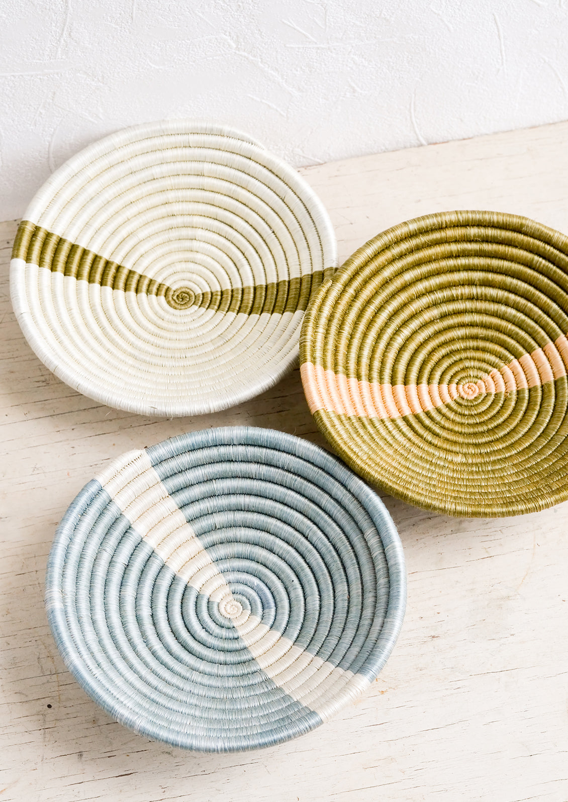 Three small sweetgrass catchall bowls in earthy tones.