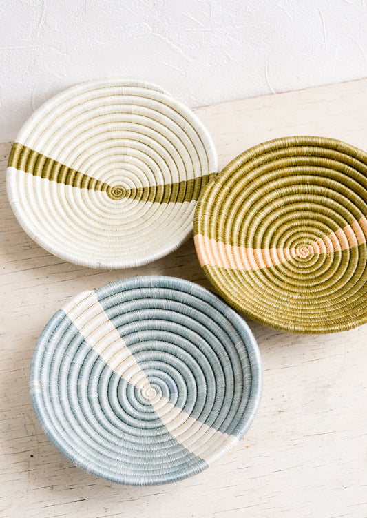 Three small sweetgrass catchall bowls in earthy tones.