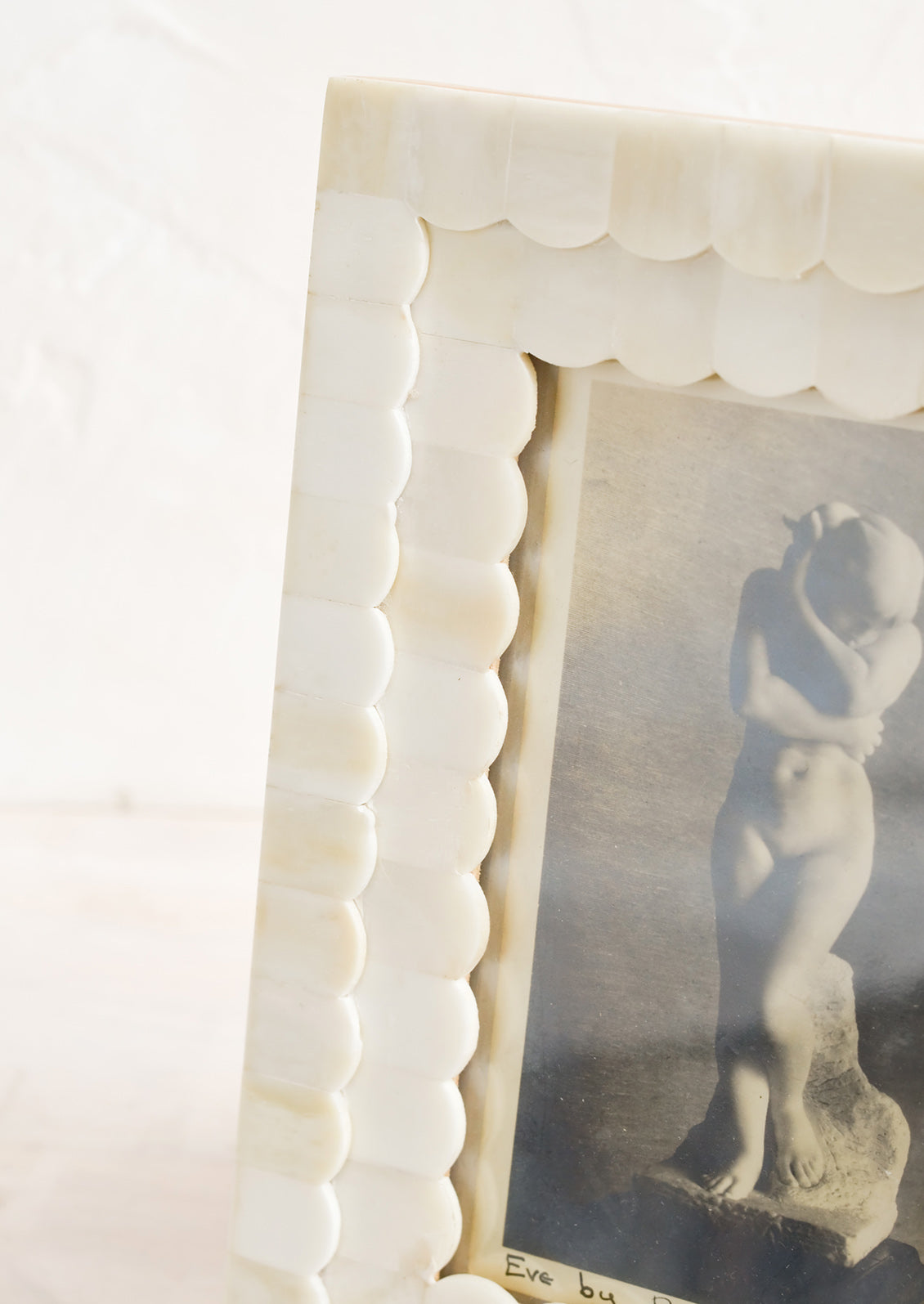 A tabletop picture frame with scalloped ivory bone border.