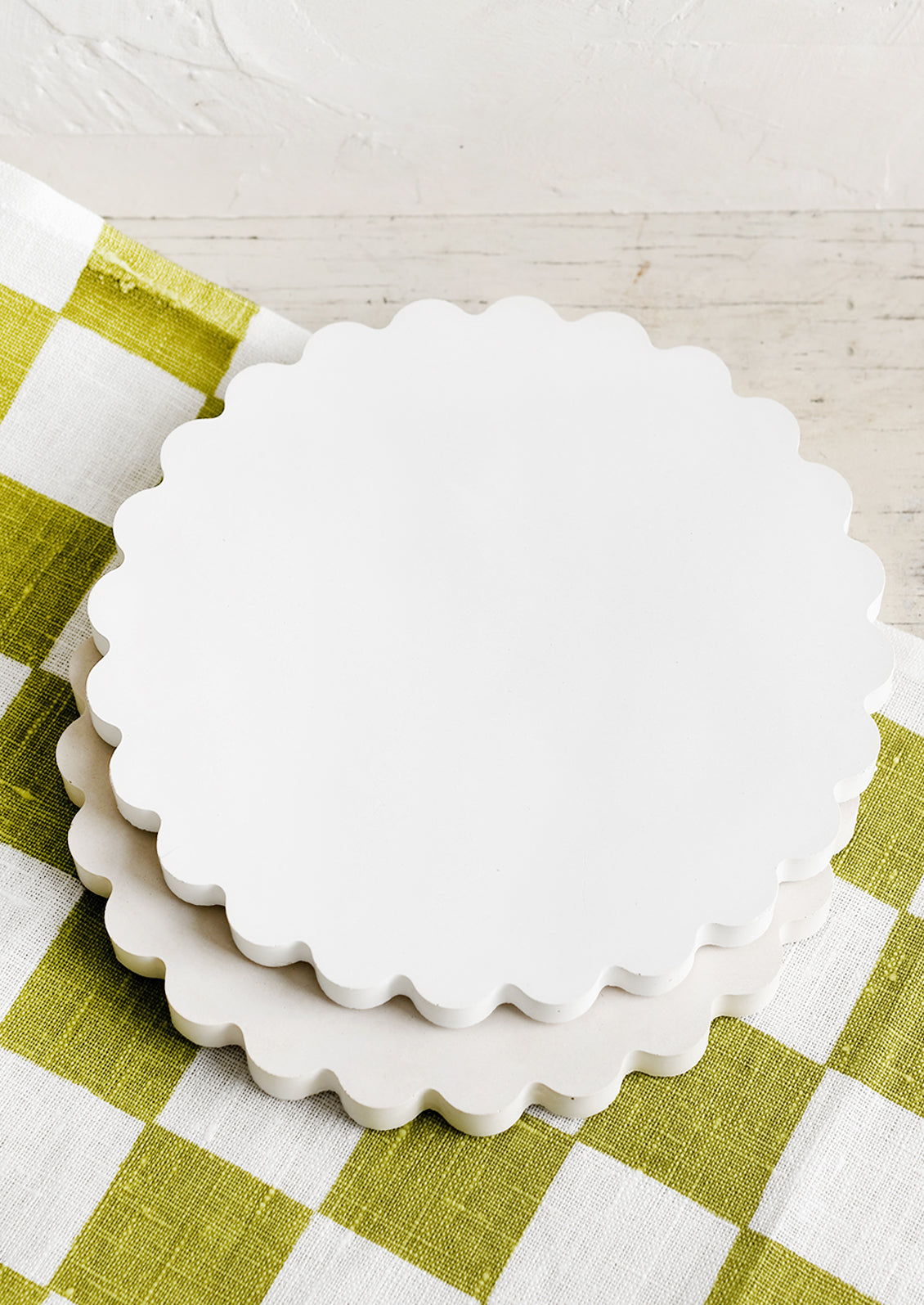 Scalloped concrete trivets in white and cream.