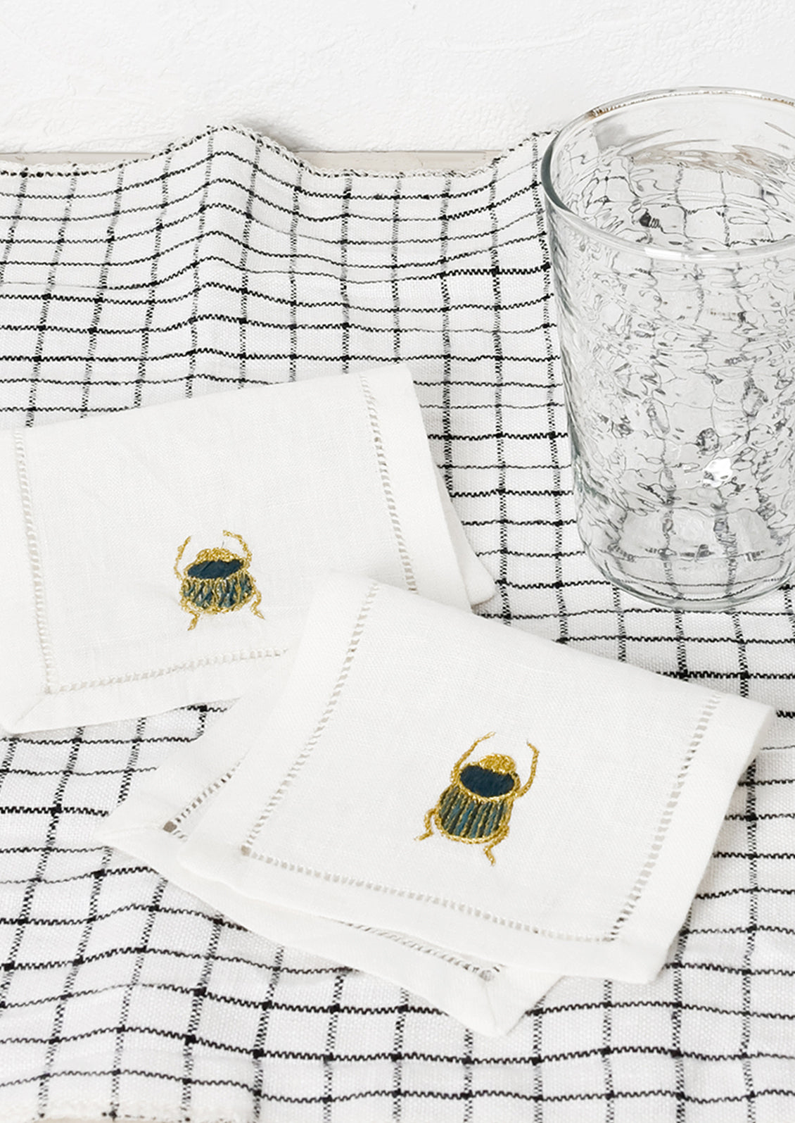 A pair of scarab embroidered cocktail napkins.