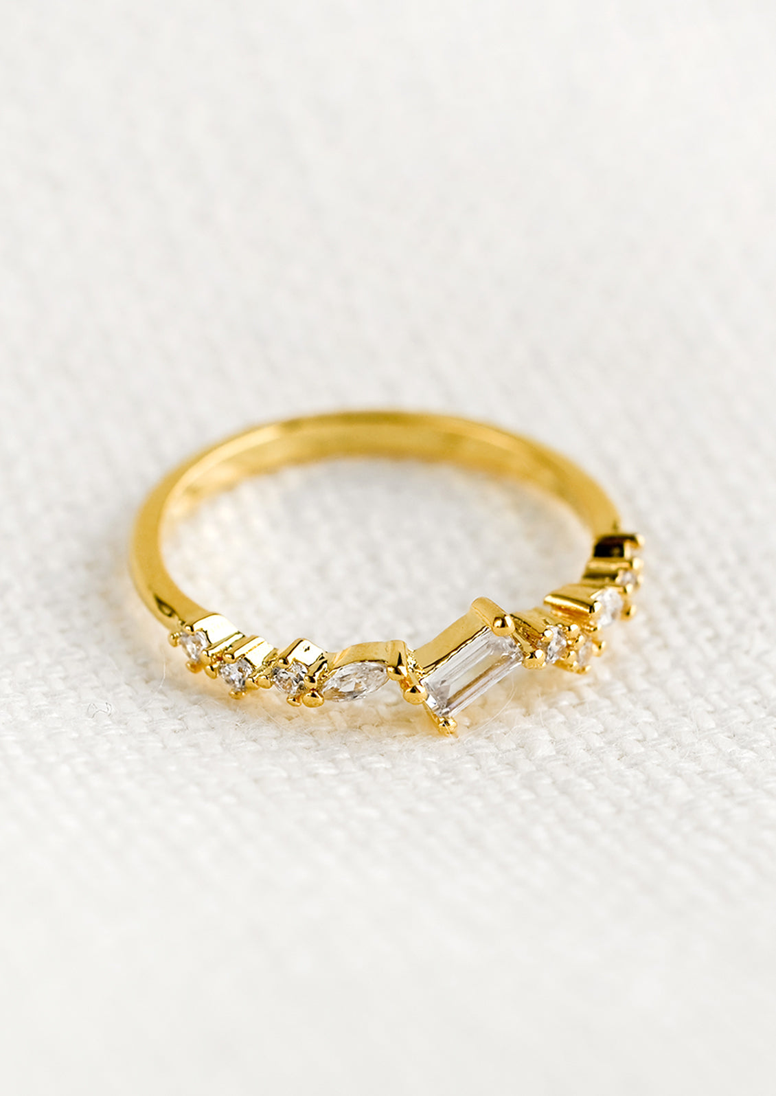 A gold ring with askew clear crystals in mixed cuts.
