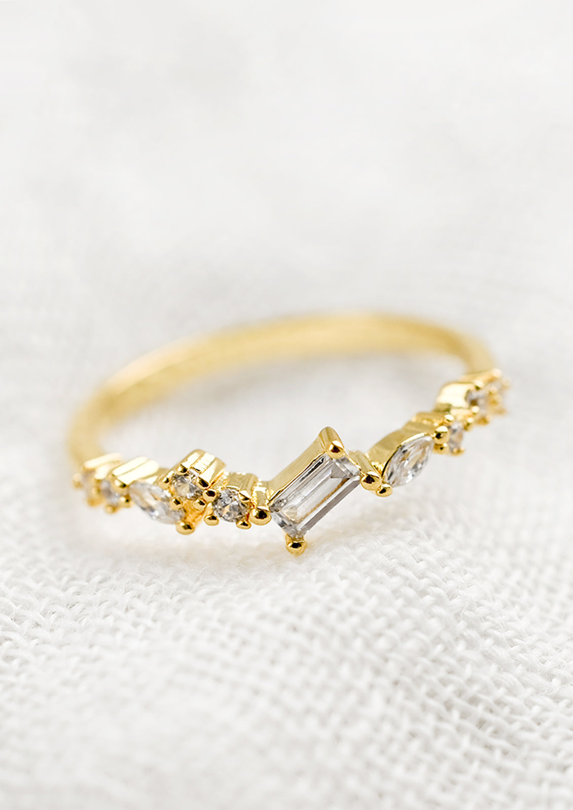 A gold ring with askew clear crystals in mixed cuts.