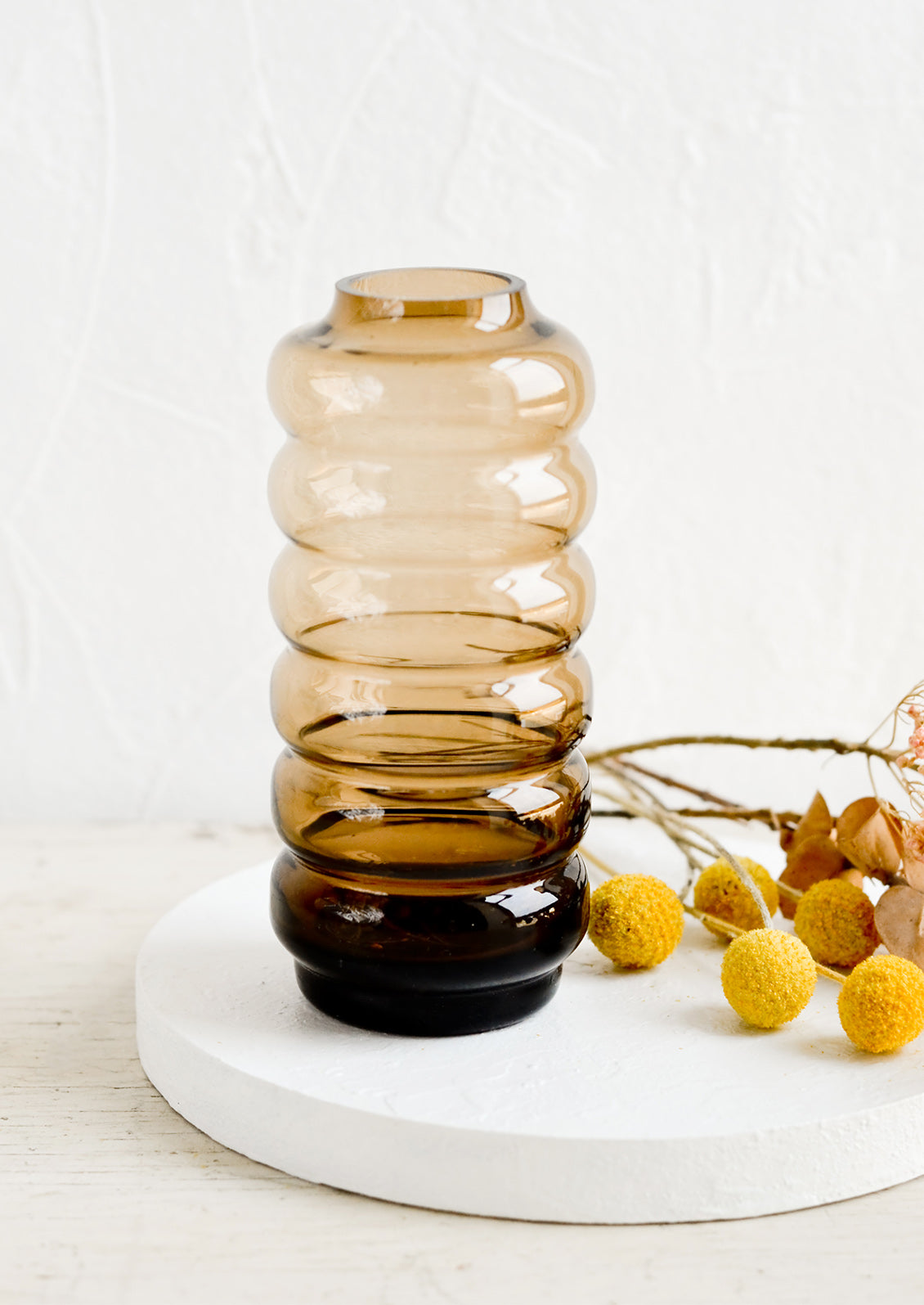 A clear brown glass vase in a curvy silhouette.