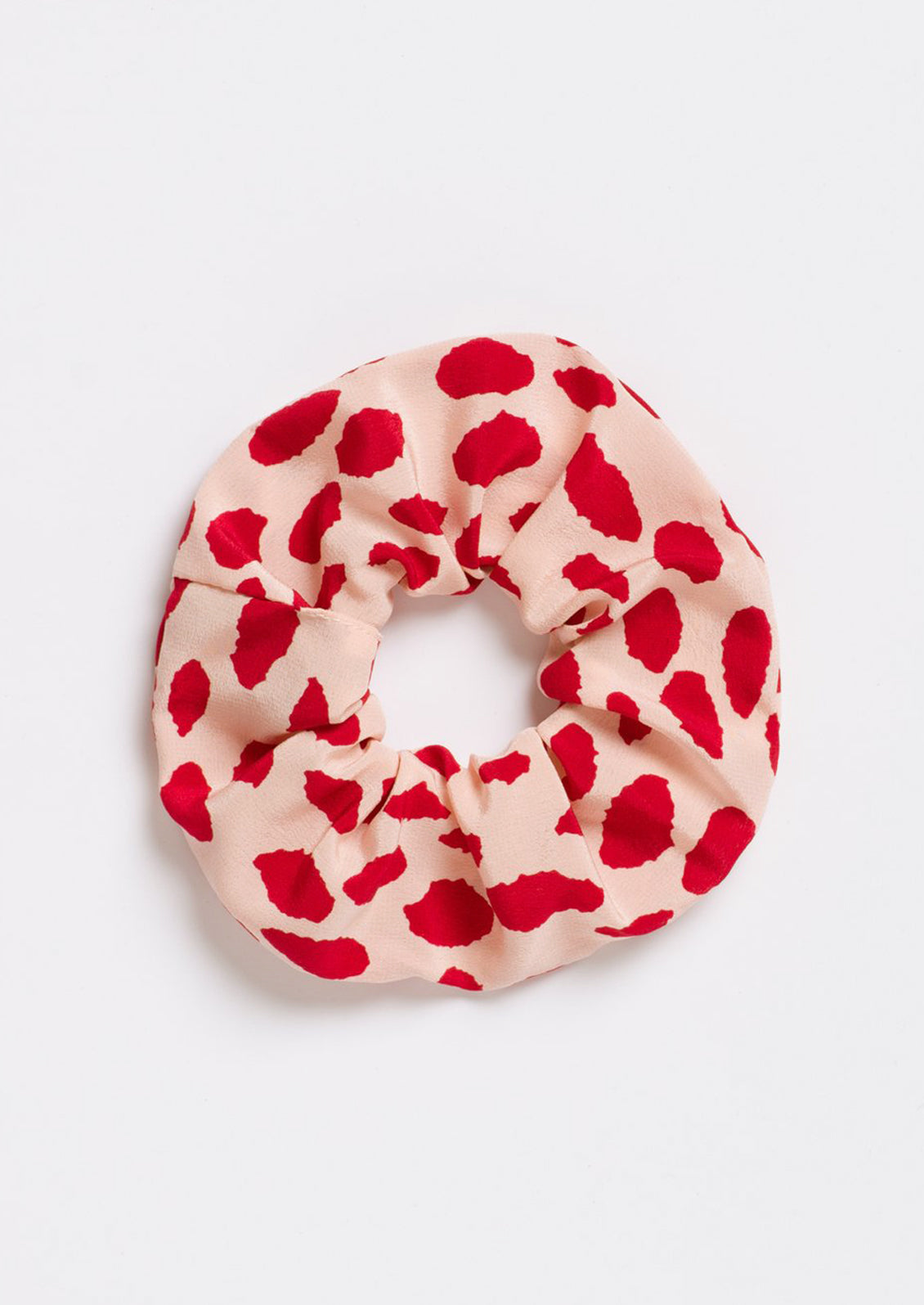 A silk scrunchie in beige with red spots.