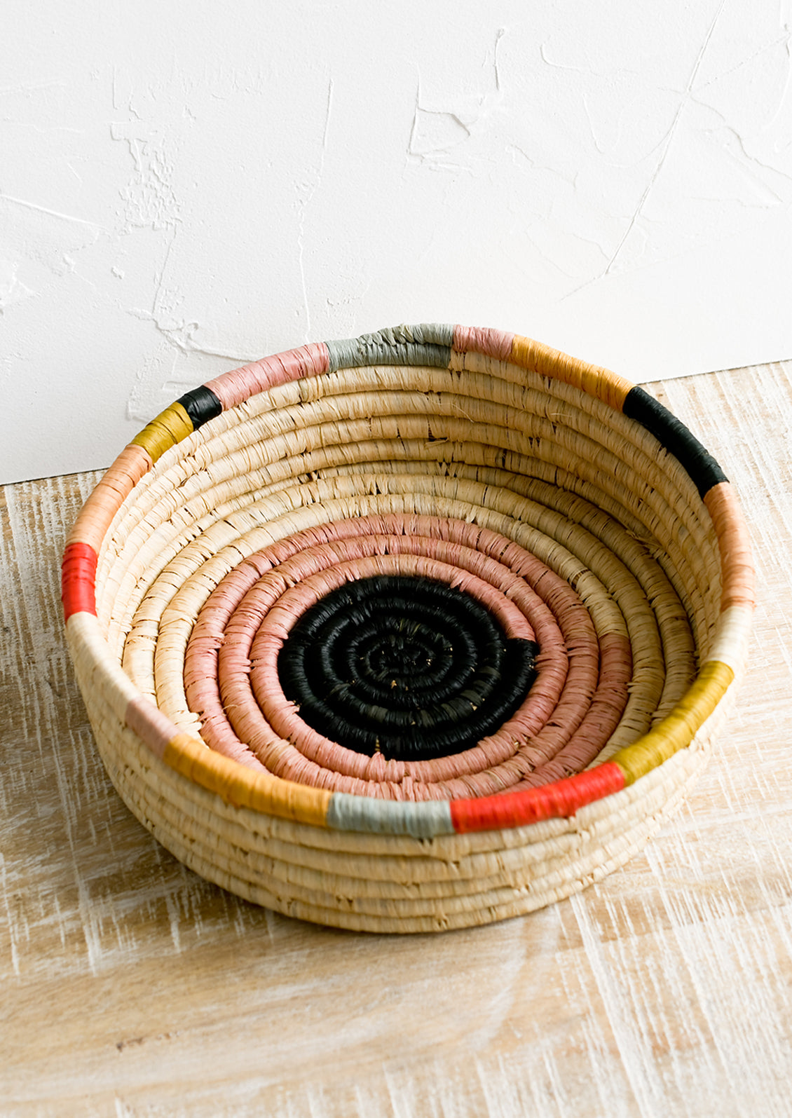 A round, shallow basket in colorful design.