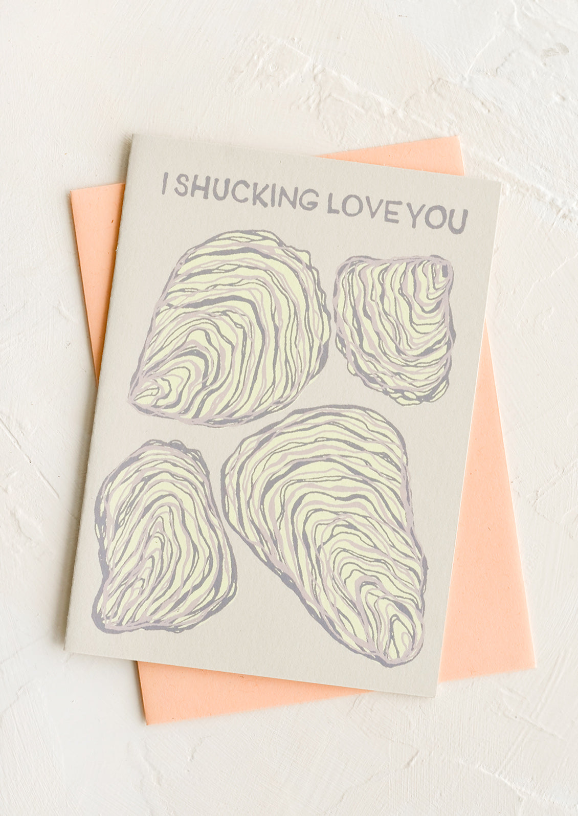 A greeting card with oyster print with text reading "I shucking love you".