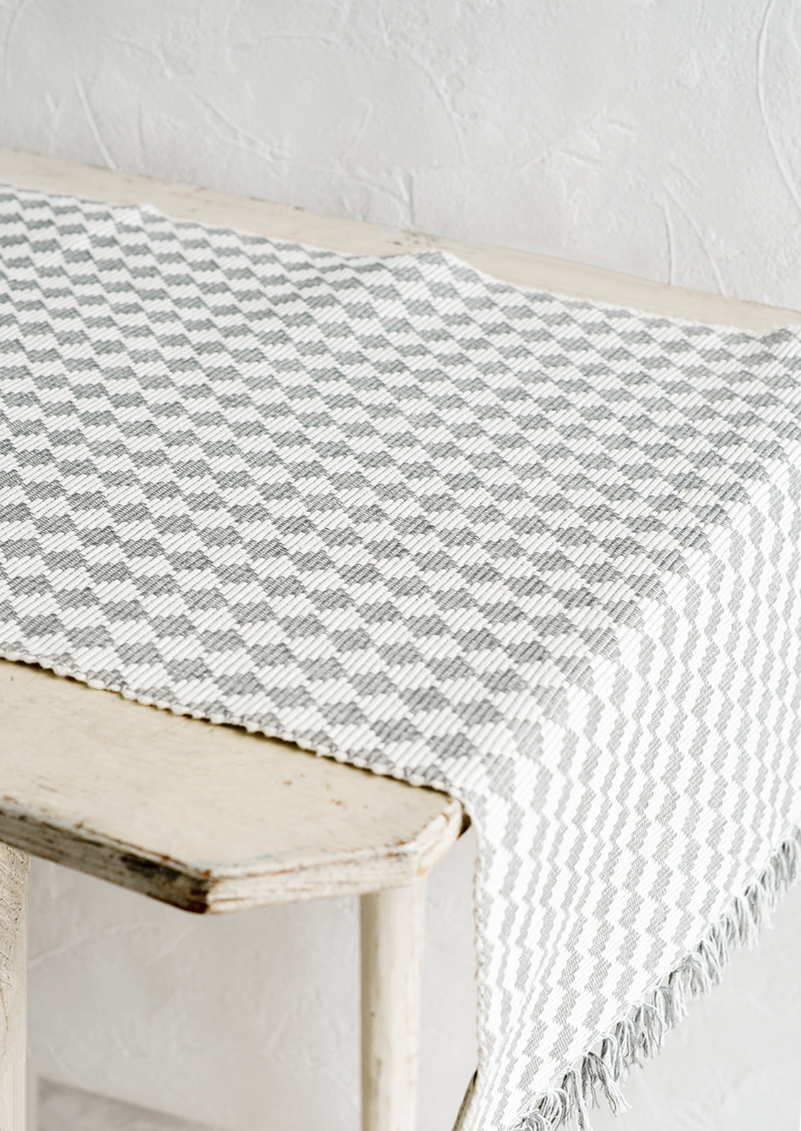 A table runner in ribbed textured grey and white checker print.