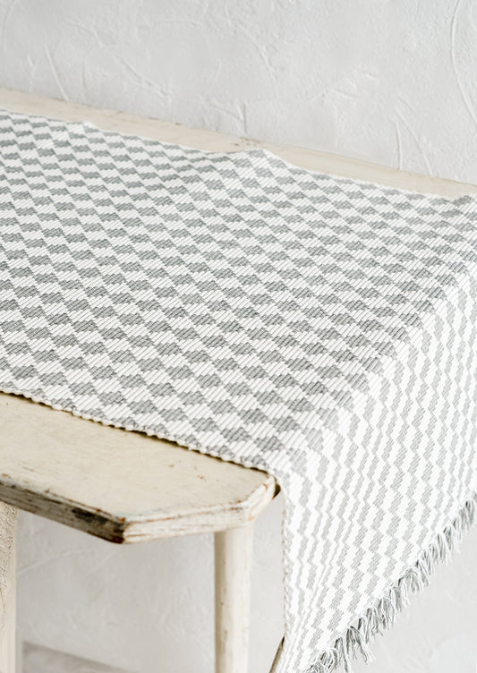A table runner in ribbed textured grey and white checker print.