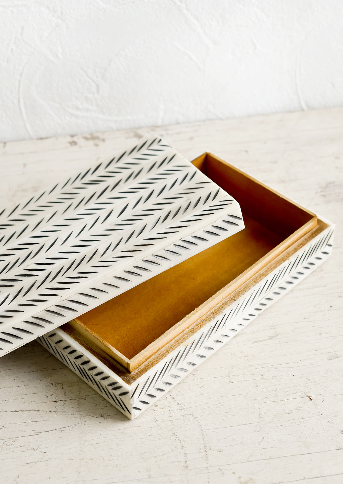 A decorative storage box with lid askew.