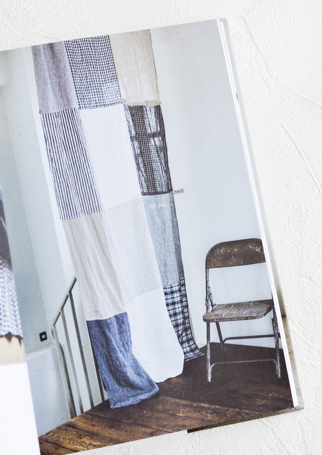 A book open to a page with a photo of a patchwork curtain.