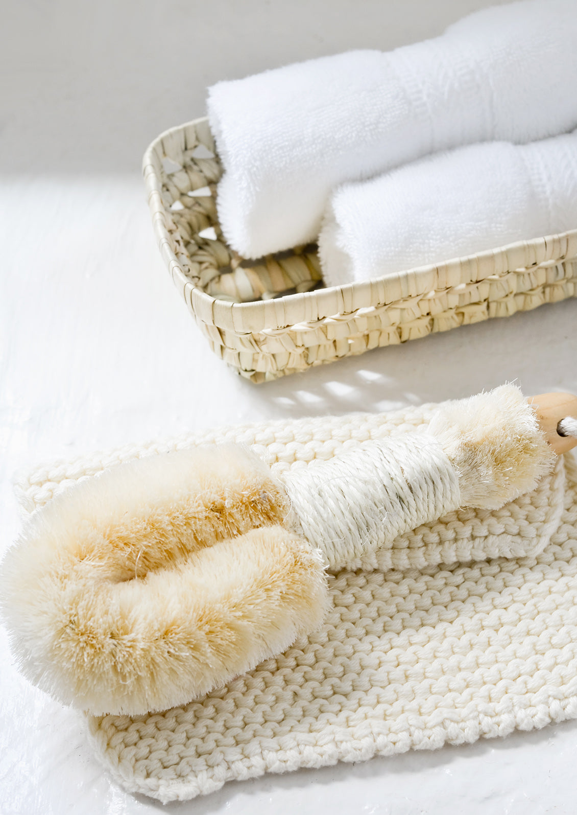 A bathroom scene featuring basket with washcloths.