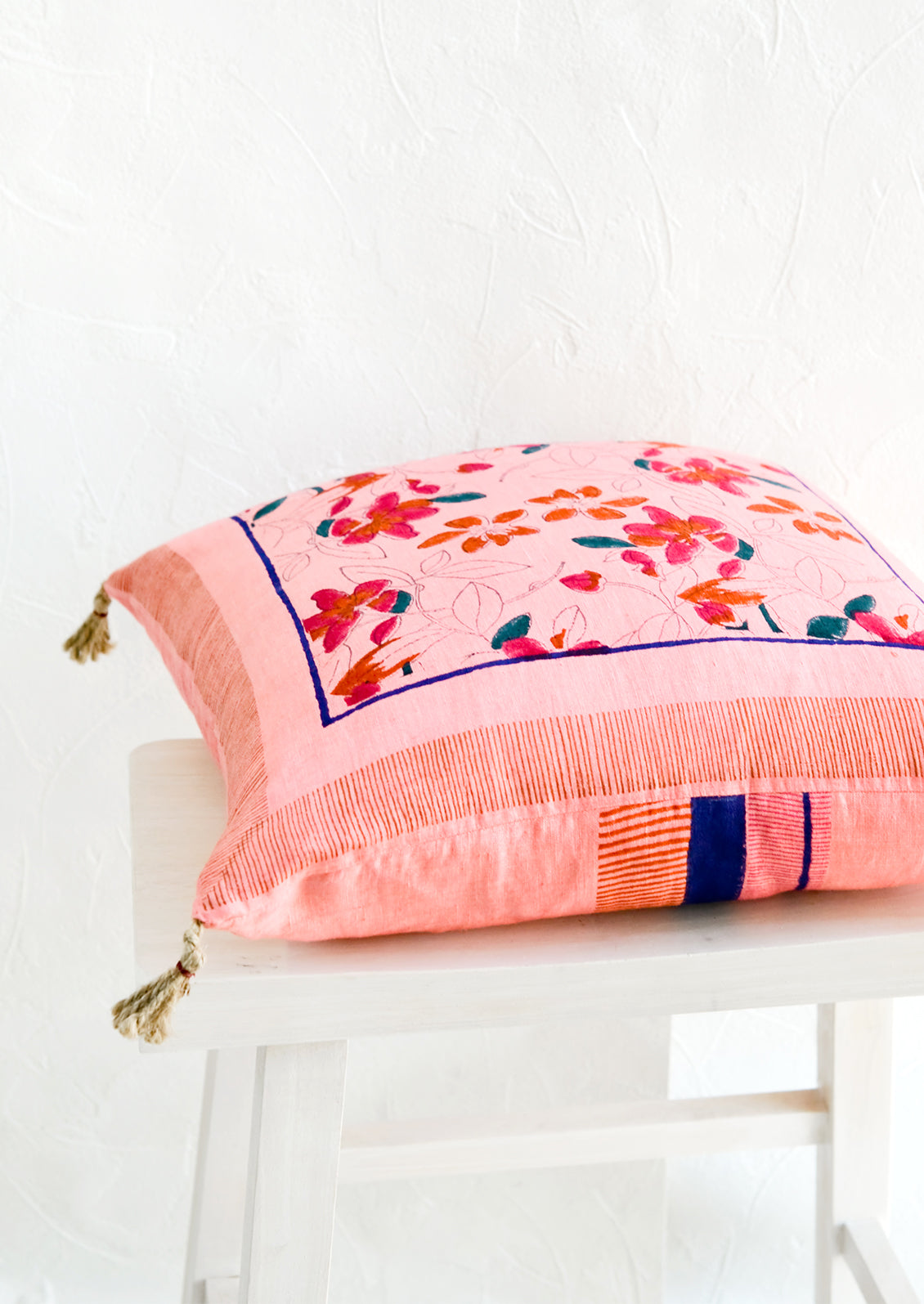 A throw pillow on its side, showing contrasting prints on front and back.