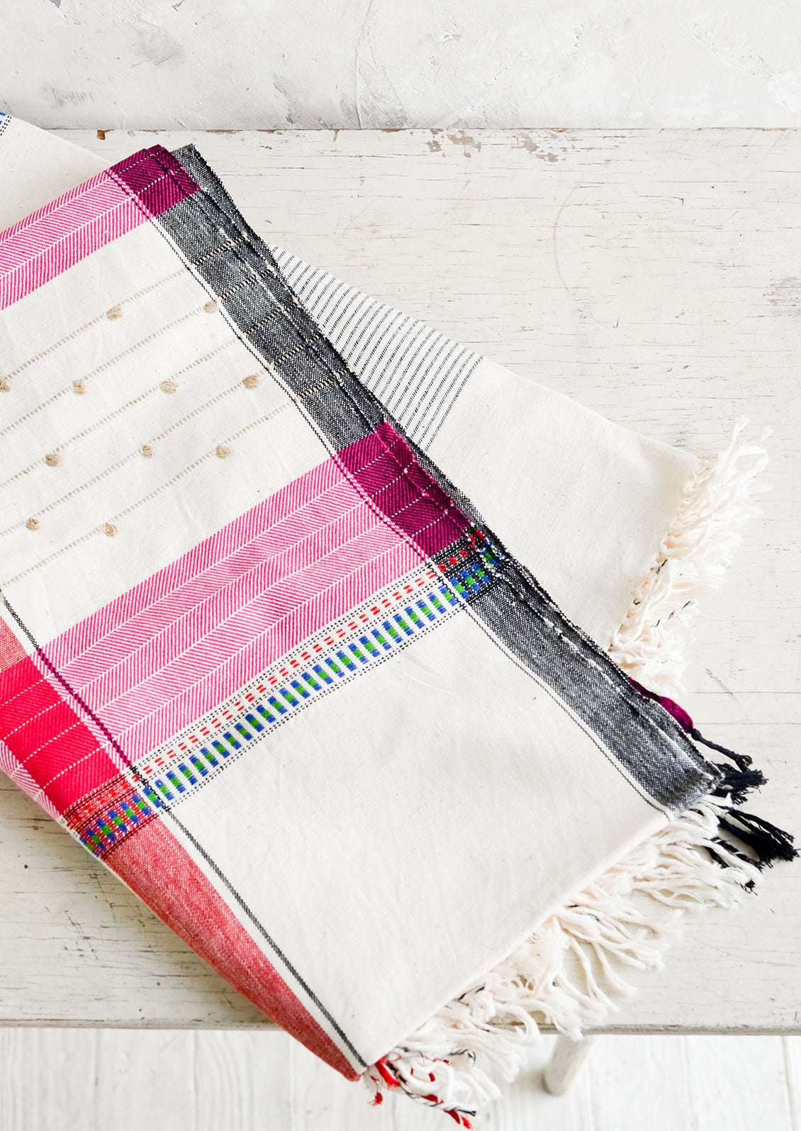 A woven cotton throw in a mix of colors and stitches.