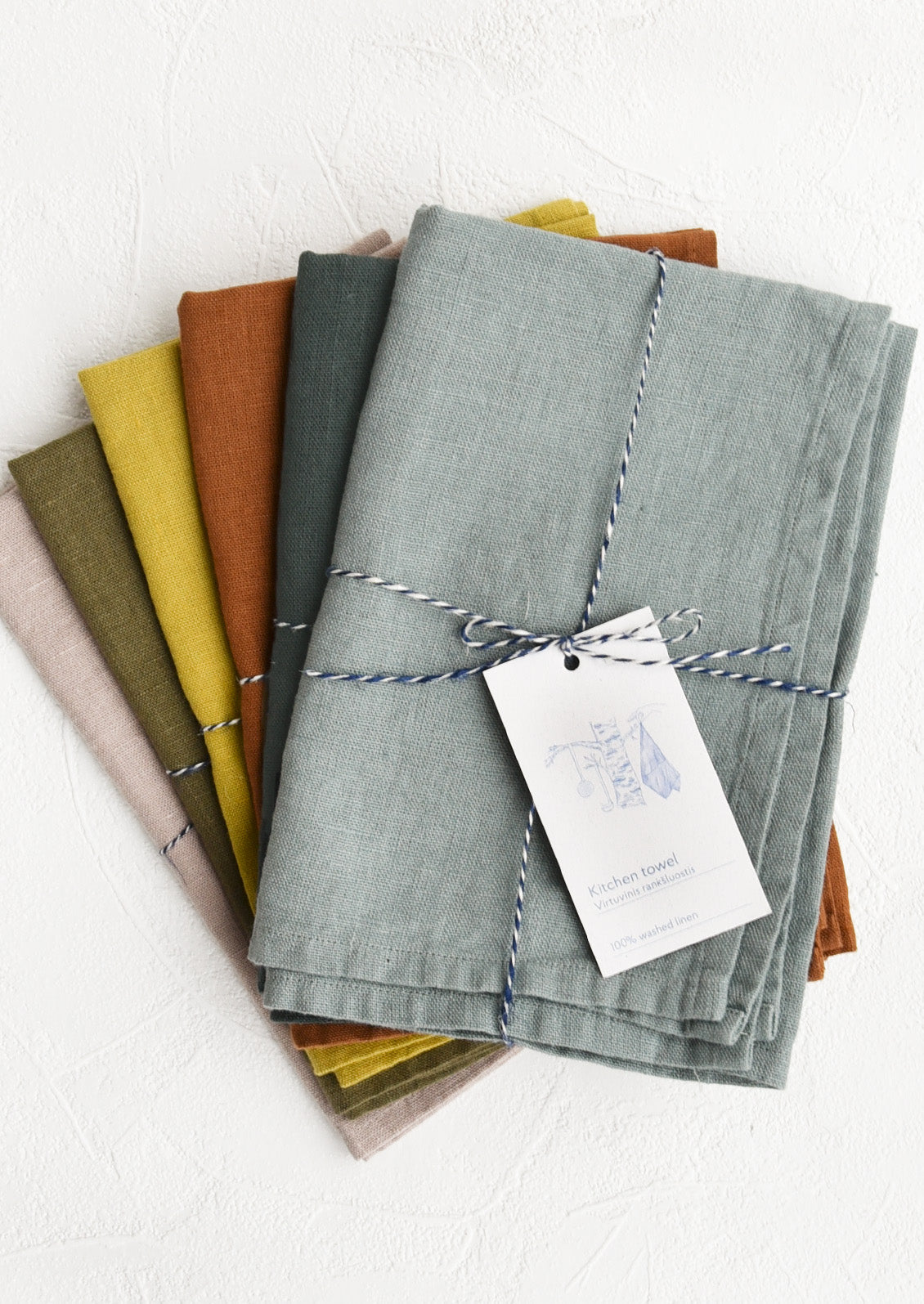 A stack of linen tea towels in assorted colors