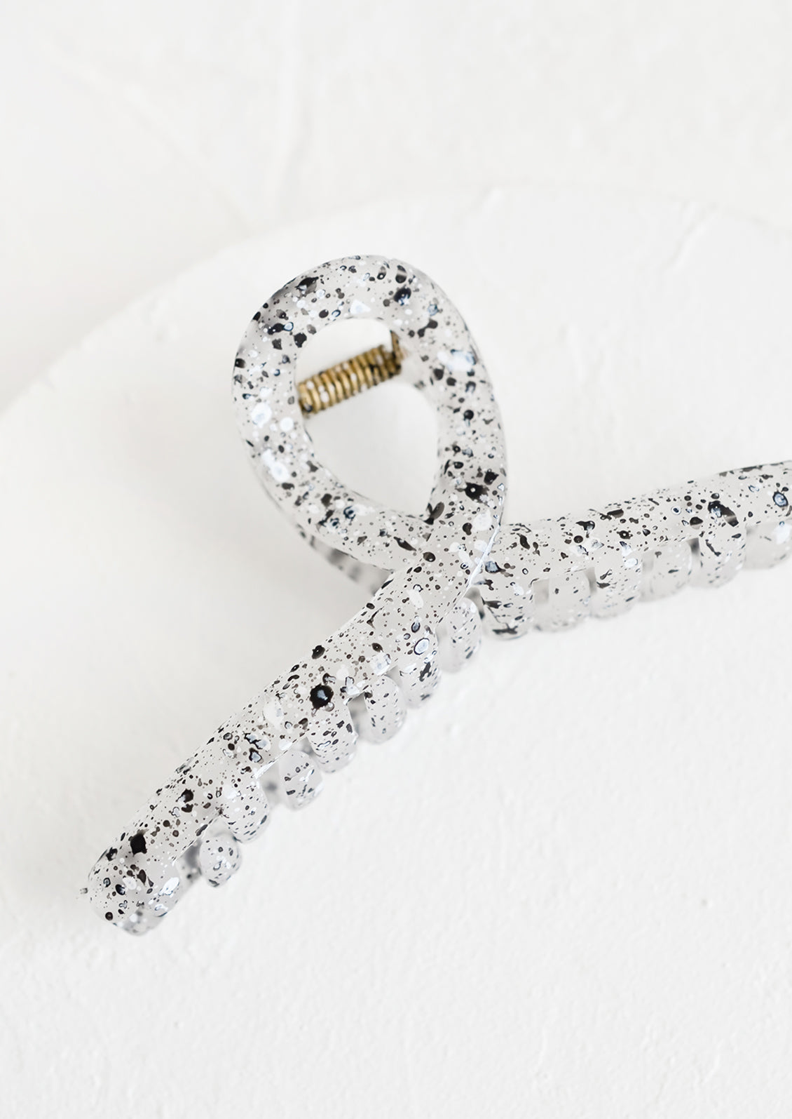 A french twist hair clip in speckled black and white.