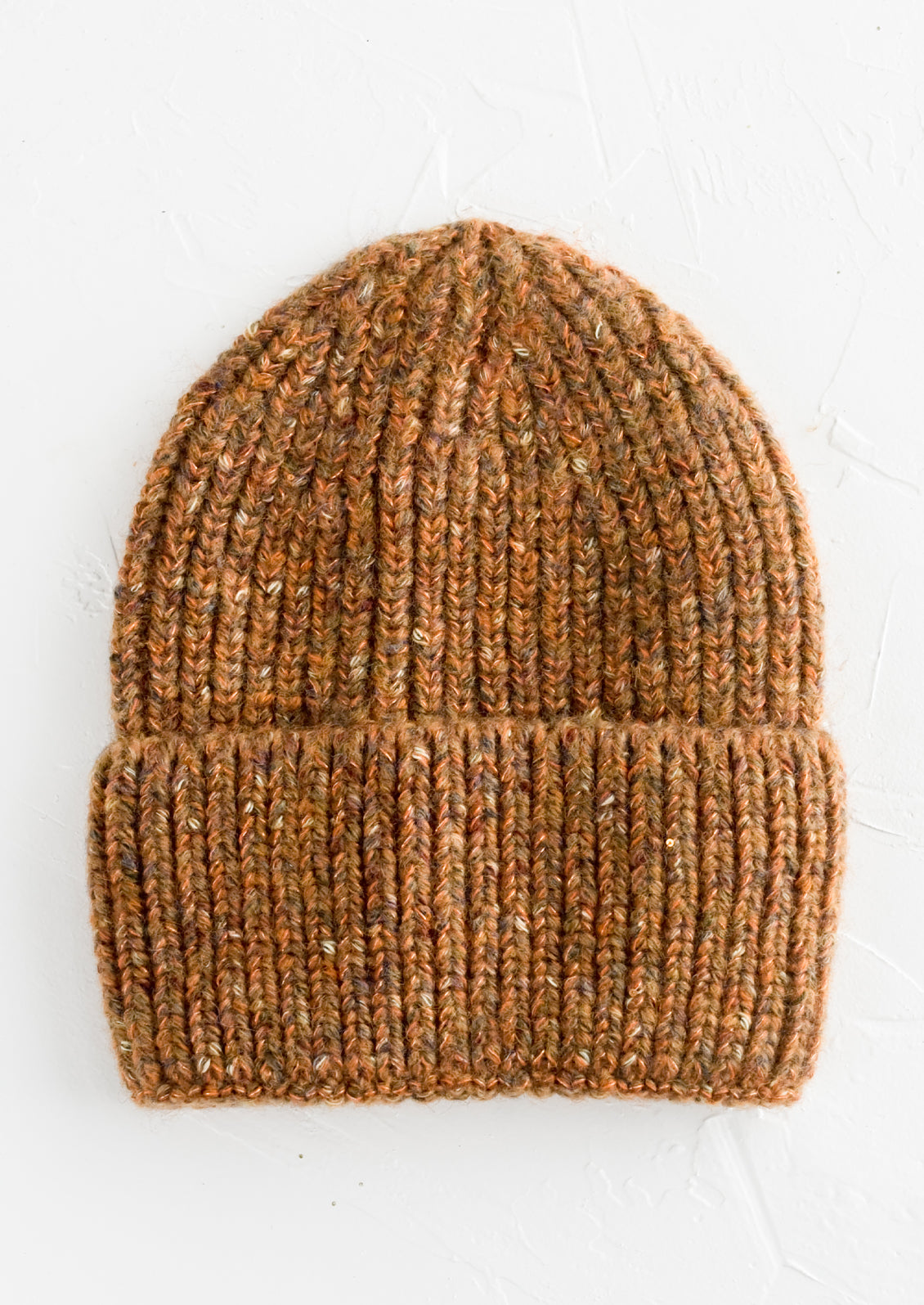 A knit beanie hat with cuffed rim made in auburn yarn with  speckles.