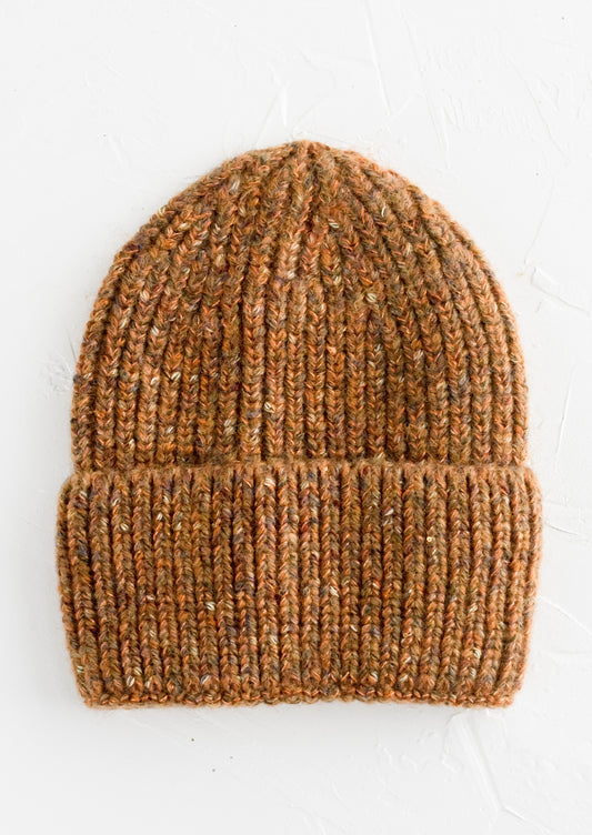 A knit beanie hat with cuffed rim made in auburn yarn with  speckles.